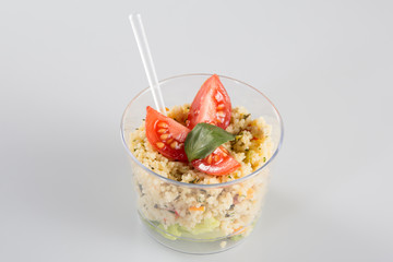 Take away healthy salad in plastic package on white background, top view