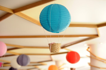 Beautiful colored paper lanterns hanging on the ceiling as air balloons