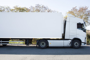 Fototapeta na wymiar Semitrailer on the rural road in sunny day your ad banner on the move