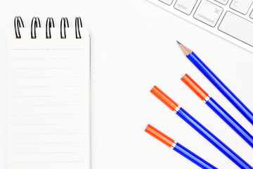 offcie desk with pencils, keyboard, and note pad