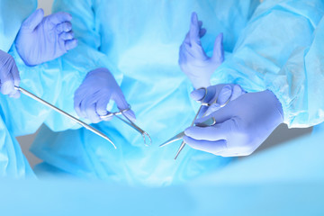 Close-up of unknown surgeons at work while operating at hospital. Health care and veterinary concept