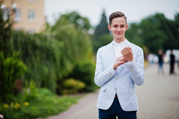 Portrait of a handsome young man in formal fancy suit posing on the pavement in the park on a prom day. © AS Photo Family
