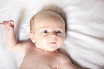 Peaceful baby lying on a bed on parent room