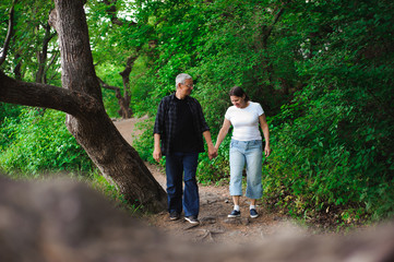 Fototapeta premium Senior couple walking together in a forest, close-up