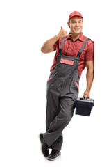 Repairman with a toolbox making a call me sign and leaning against a wall