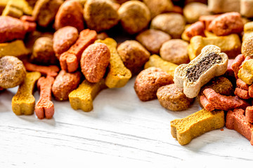 dry dog food in bulk on wooden background close up