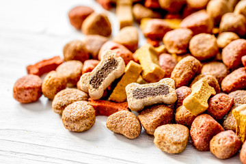 dry dog food in bulk on wooden background close up