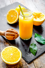 Fototapeta na wymiar freshly squeezed orange juice in glass bottle on wooden backgrou