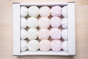 Multicolored marshmallow in a pack on a wooden background