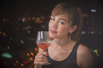 Happy asian woman with red cocktail