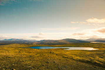 Fototapeta na wymiar A beautiful mountain lake high above the sea level in Norway. Colorful autumn landscape with lake.