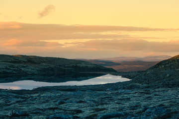 A beautiful mountain lake high above the sea level in Norway. Colorful autumn landscape with lake.