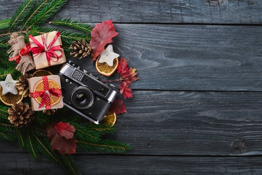 Camera Christmas wooden background. New Year's holiday. Christmas motive. On a wooden surface. Top view. Free space for your text.