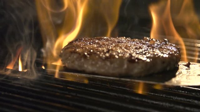 Aged prime rare roast grilling tenderloin fresh juicy beef filet with lines slow motion. Closeup blur macro concept of person cooked unhealthy satisfying hamburgers outdoors for friends picnic party