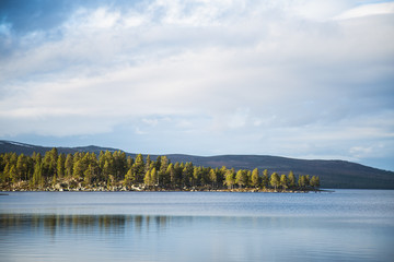 A beautiful lake landscape in Femundsmarka National Park in Norway. Lake with a distant mountains in background. Beautiful autumn scenery with vivid colors.