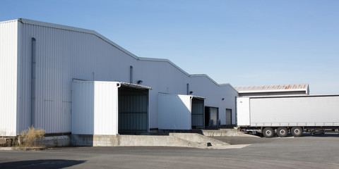 Forklift and trucks at cargo dock of warehouse at the loading docks