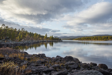 A beautiful lake landscape in Femundsmarka National Park in Norway. Lake with a distant mountains in background. Beautiful autumn scenery with vivid colors.