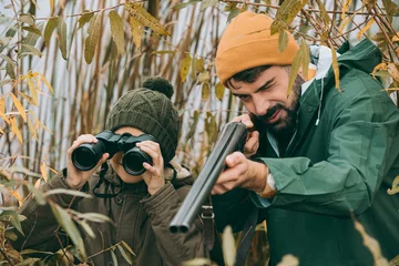 Fotobehang Father aiming at animal with gun © LIGHTFIELD STUDIOS