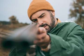 Hunter aiming at something with gun