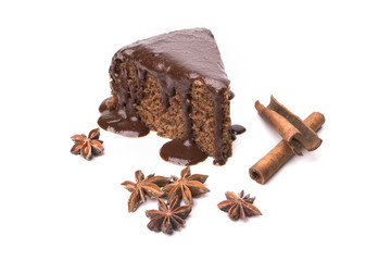 A piece of chocolate cake, cinnamon sticks and anise star isolated on white background