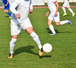 Men are playing soccer outdoor in summer