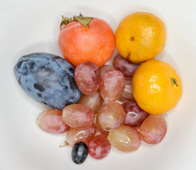Natural-looking fruits  - grapes, mandarin, plum and persimmon.