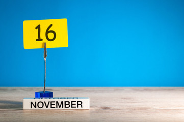 November 16th. Day 16 of november month, calendar on workplace with blue background. Autumn time....