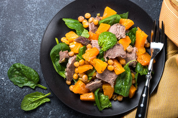 Warm salad with pumpkin, baked beef, spinach and chickpeas.