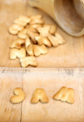 English alphabet made from biscuit in wooden dipper.