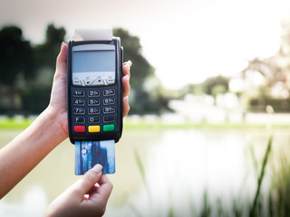 credit cards swipe through terminal on nature background,Economy,Revenue and expenditure on human life.