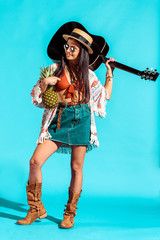 woman standing with pineapple and guitar