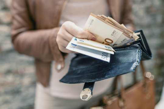 Woman holding in hands wallet with euro money