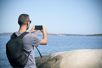 young man taking a picture in Sardinia, Italy