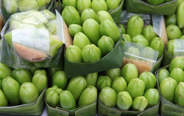 Green Bilimbi or Ta Ling Pling fruit sour taste dipping with salt pepper on banana leaf ready for sale.