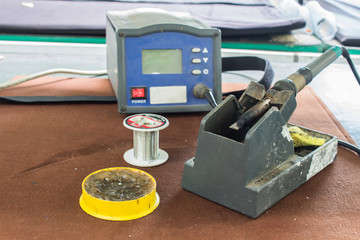 The soldering tools, tin, soldering iron, rosin on table.