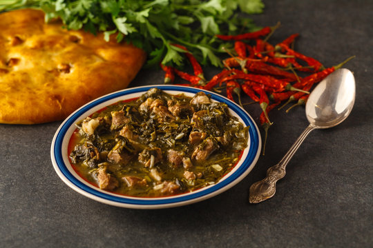 meat and greens soup from lamb with a spoon with greens
