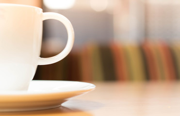 a white cup of tea or coffee on a wooden table in a Cafe close-up with copy space