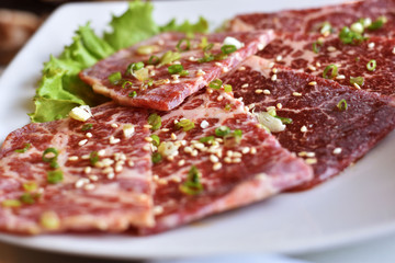 pork shoulder with garlic source on white plate Korean grill style