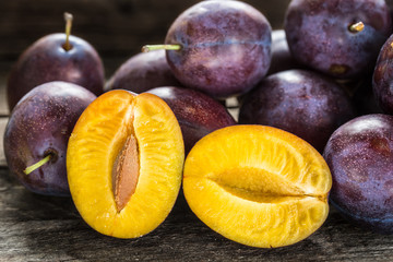 Fresh blue plums on wooden table