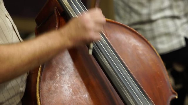 Hands playing the contrabass close up