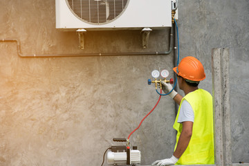 asian man runs the air-conditioning refrigerant from the tank