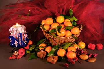 tangerines. still life  a wicker basket full of mandarin, lit by the light of a candle, Christmas...