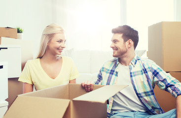 Fototapeta premium smiling couple with many boxes moving to new home