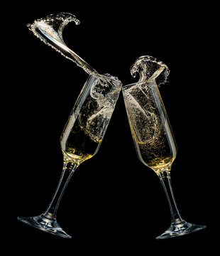 Glasses of champagne with splashes on a black background