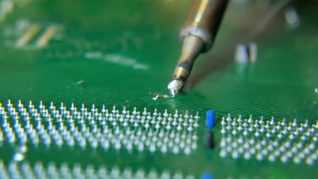 Electronics Engineer is Soldering an Electric Board repair computer.