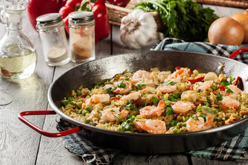 Traditional seafood paella with shrimp, fish and chicken seved in paellera
