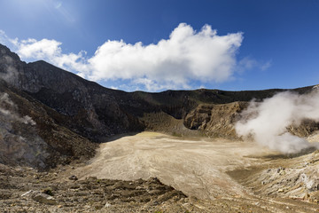 The caldera on Mount Egon with a small acidic lake and sulphuric gasses coming from within the volcano.