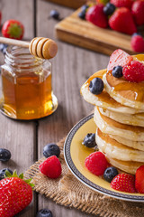 pancakes with fruits and honey shot on wood boards close-up portrait