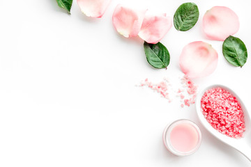 Obraz na płótnie Canvas Pattern with rose oil cosmetics. Rose petals, spa salt on white background top view copyspace