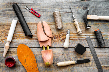 Fototapeta na wymiar Shoe repair. Wooden last, hammer, awl, knife, thread on wooden background top view